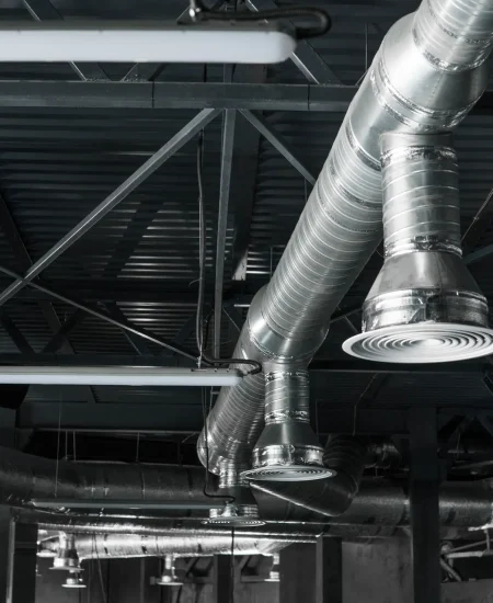 Ventilation system on the ceiling of large buildings. Ventilation pipes in silver insulation material hanging from the ceiling inside new building